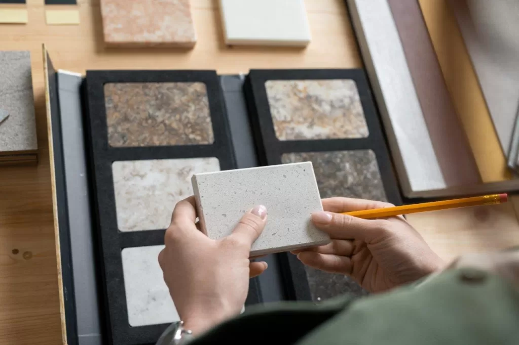 hands of young female designer holding sample of granite